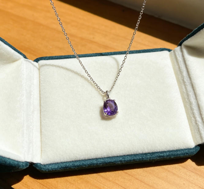 A close-up of a sparkling diamond necklace in a red gift box