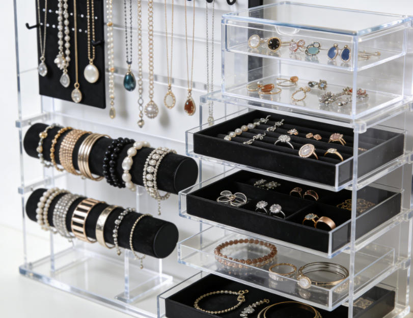A large jewelry collection organized with hanging organizers and stacked trays.